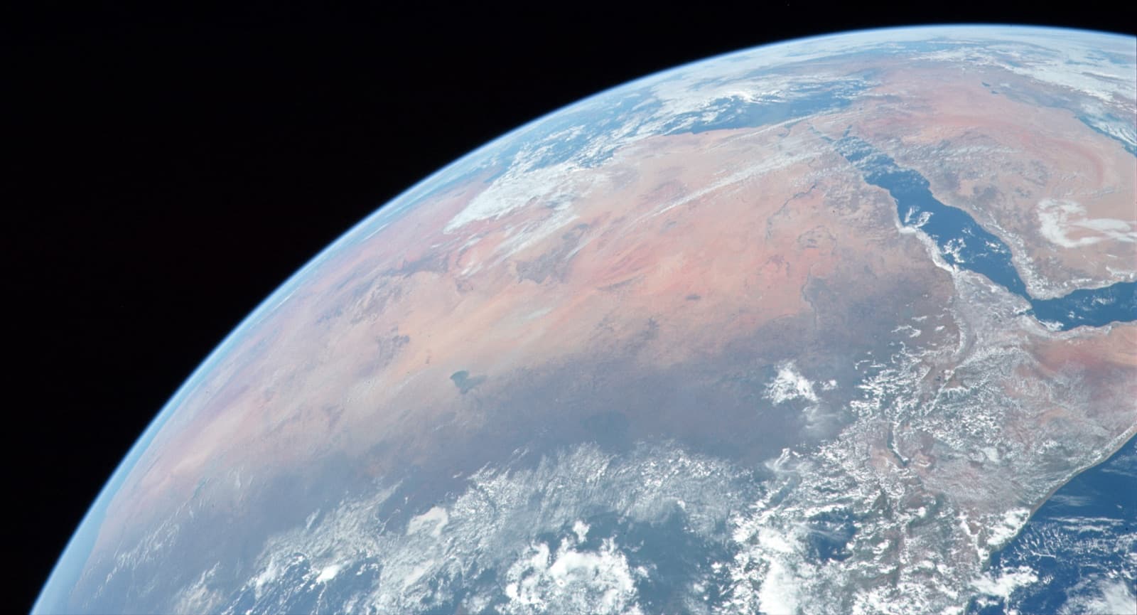 The Sahara seen from space, a vast band of golden sand across northern Africa