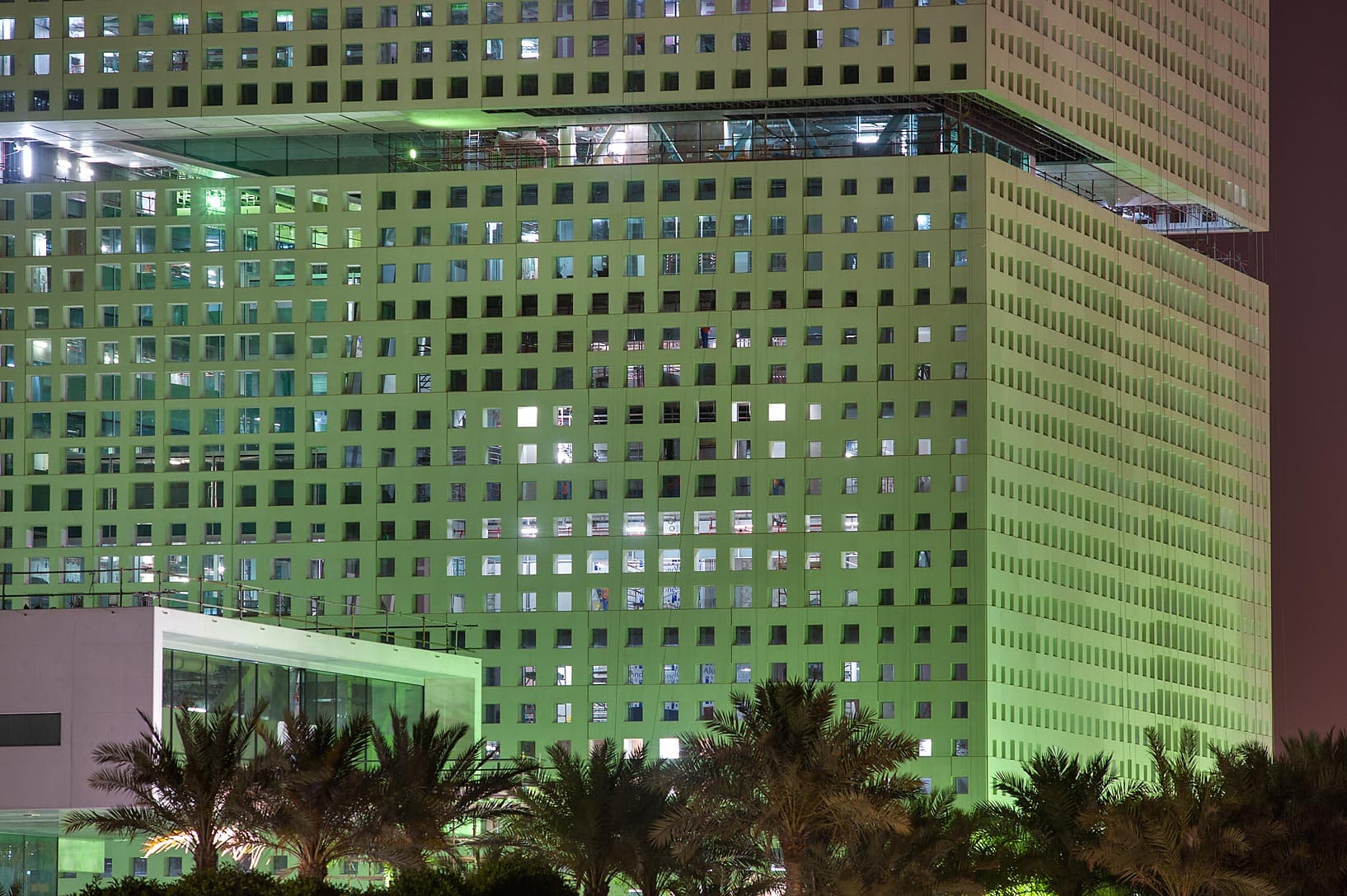 The striking angular glass building of Education City's Qatar National Library surrounded by greenery