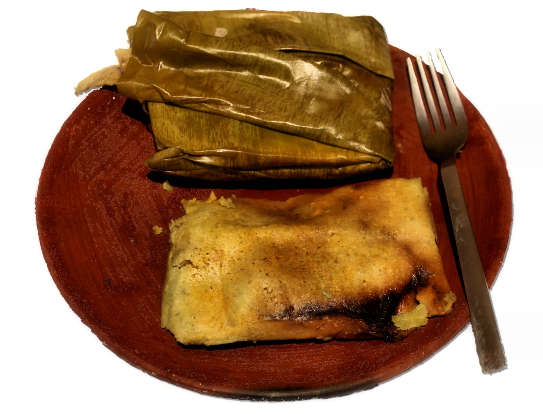 Guatemalan tamales wrapped in banana leaves, ready to steam