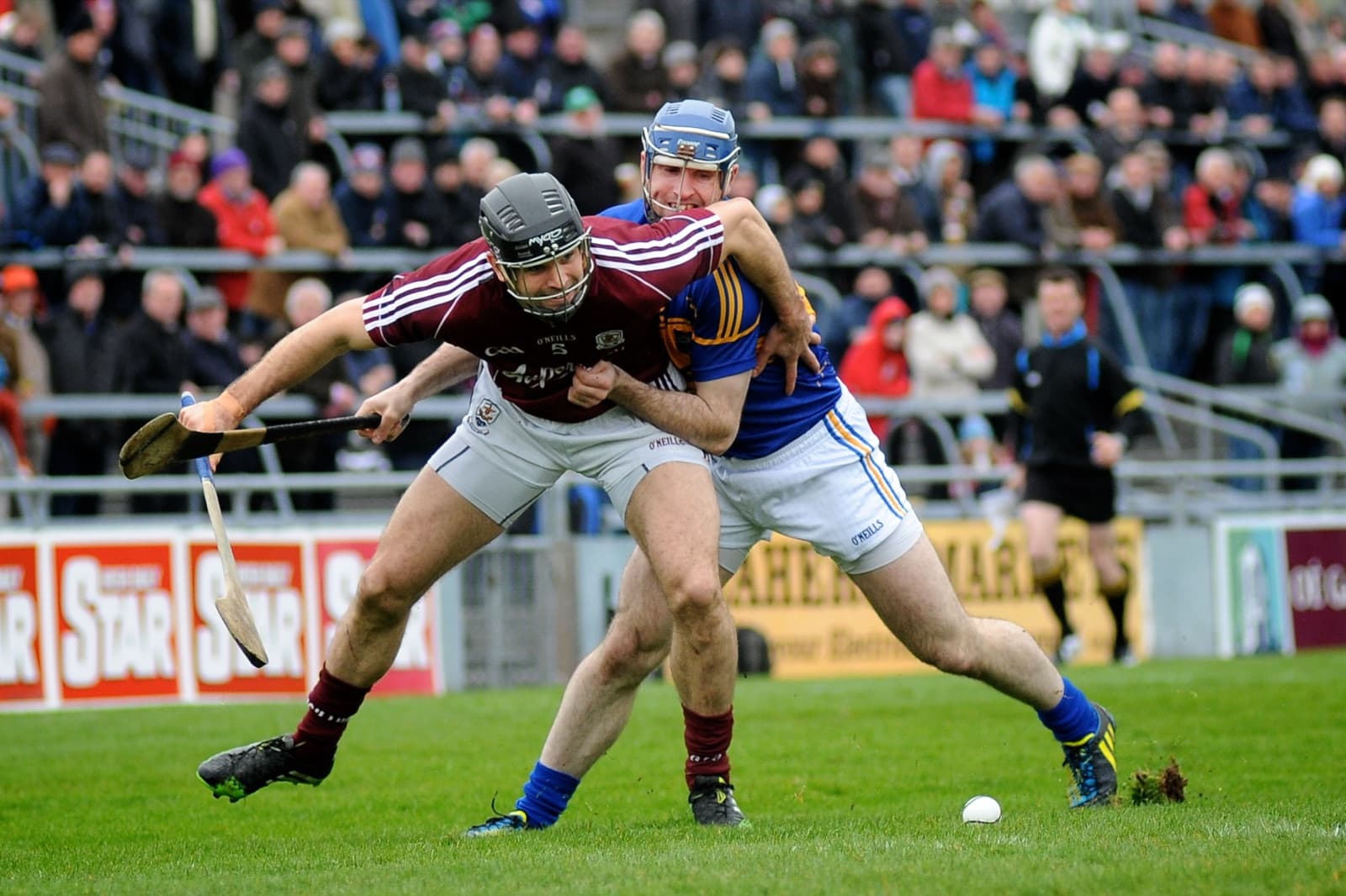 A hurling player striking a sliotar with a wooden hurley