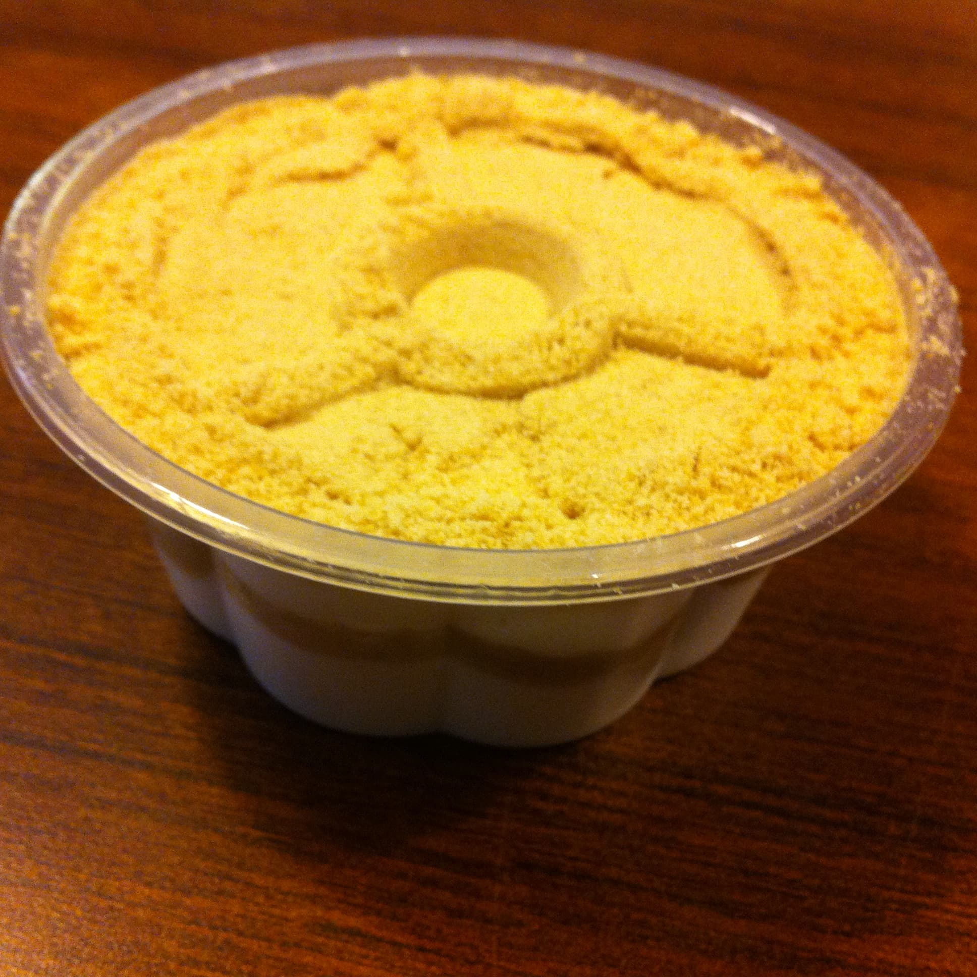 A glass cup of creamy serradura pudding with biscuit crumbs on top